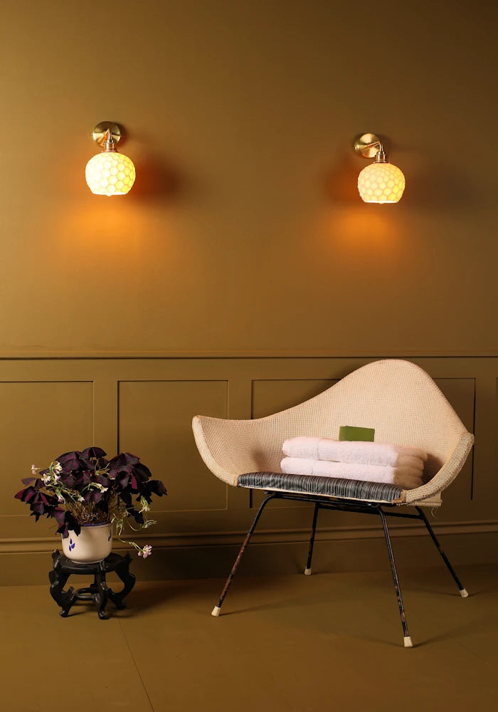 Elegant honeycomb effect ceramic IP44 bathroom wall lights, art deco chair, bath towels, pot plant