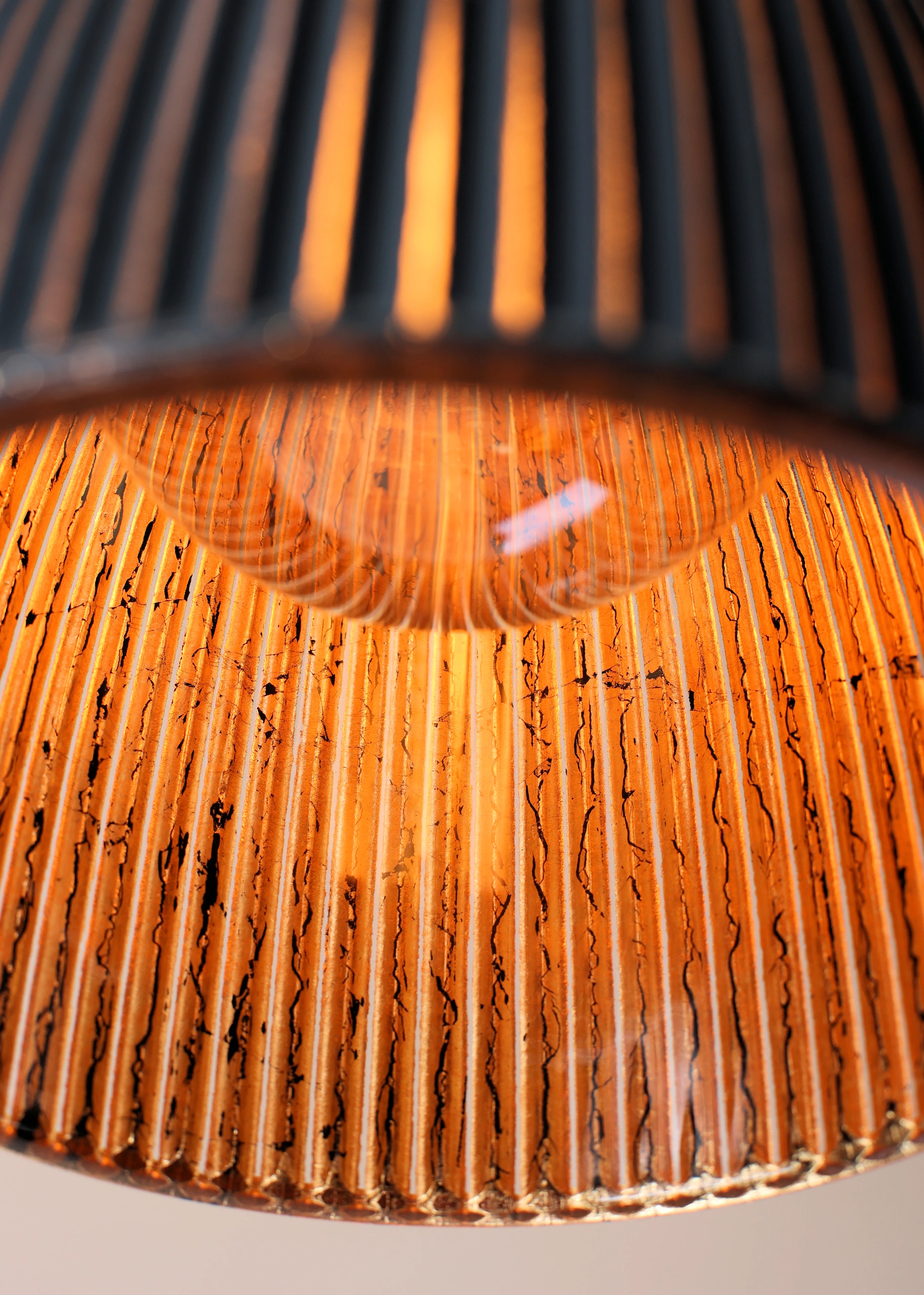 Close-up of a textured lampshade with a warm glow