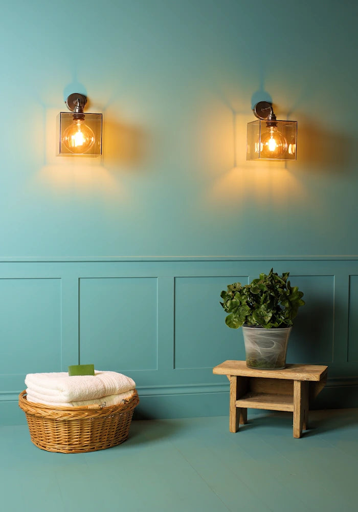 Elegant square smoked glass IP44 bathroom wall lights, basket with bath towels, pot plant