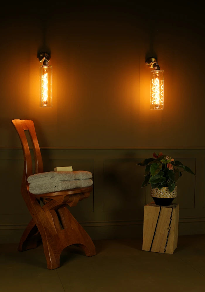 Elegant glass IP44 bathroom wall lights, wooden chair with bath towels, pot plant