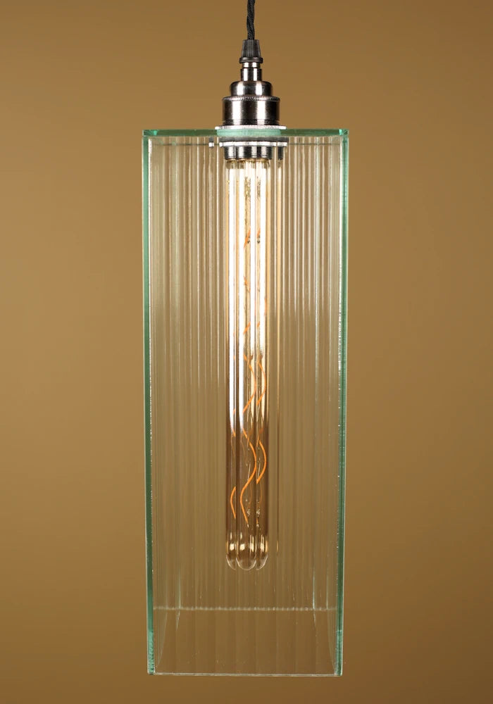 Fluted glass pendant light with glass shade, nickel lamp holder on a brown background
