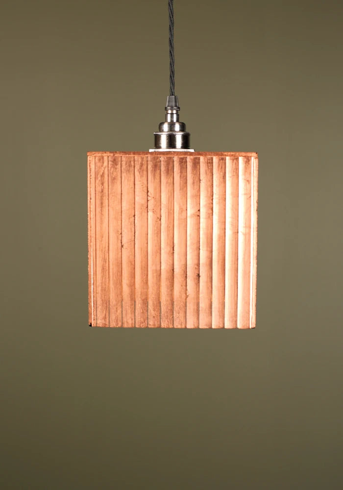 Square copper pendant light with nickel lamp holder or a green background