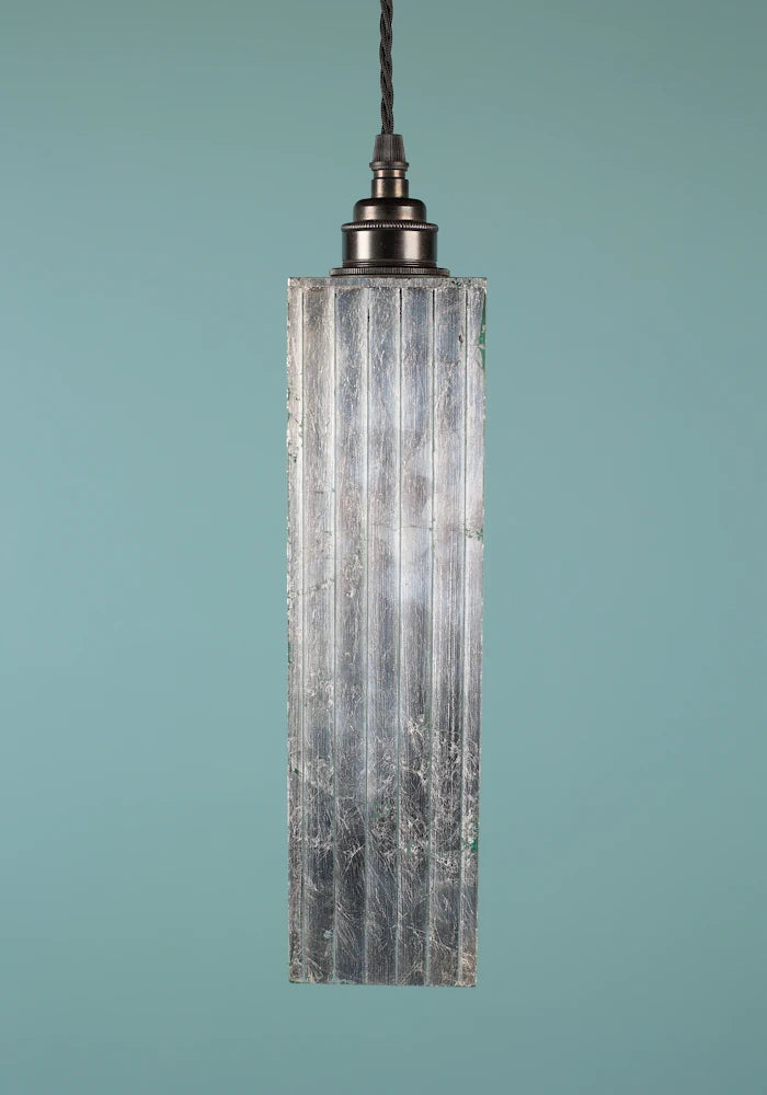 Slim, elegant silver pendant light with bronze lamp holder on blue background