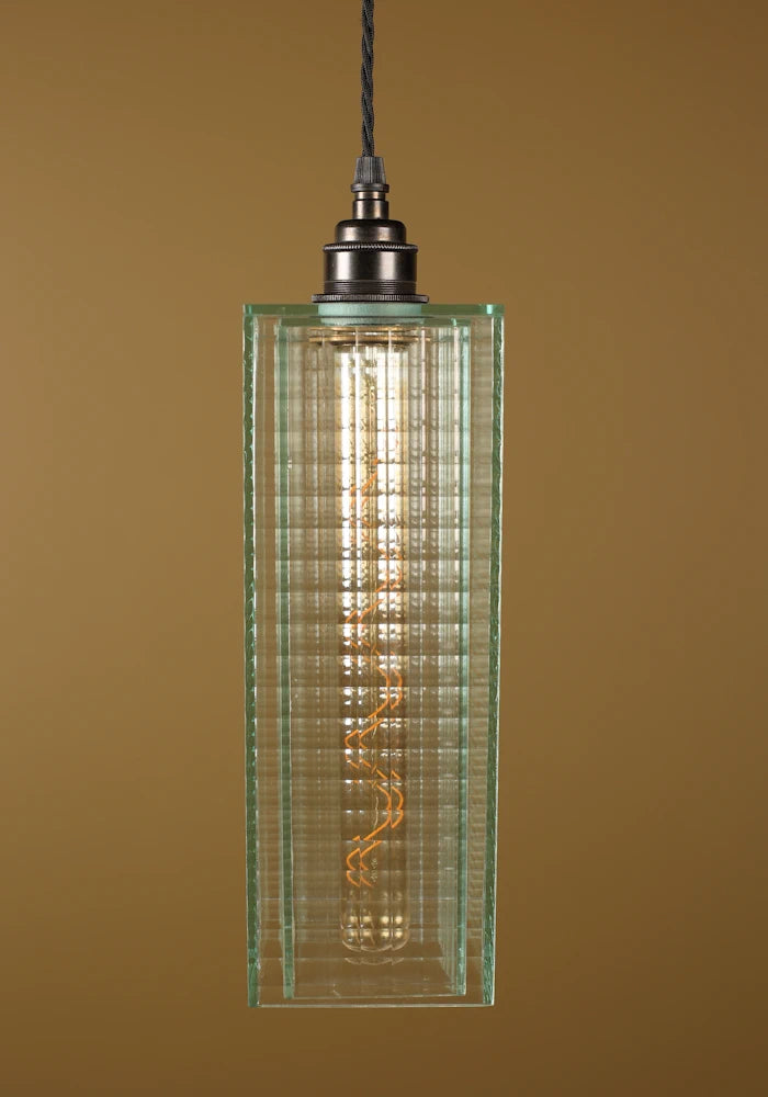Pendant light with a green glass shade, bronze lamp holder on a brown background