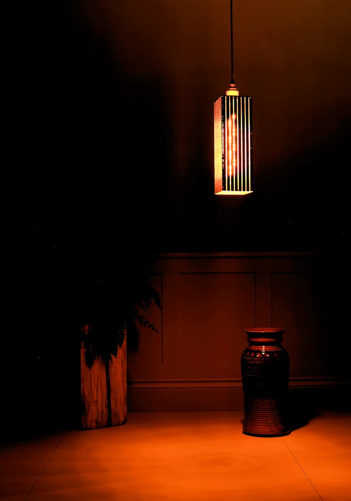 Pendant light fixture casting a warm glow in a dimly lit room.