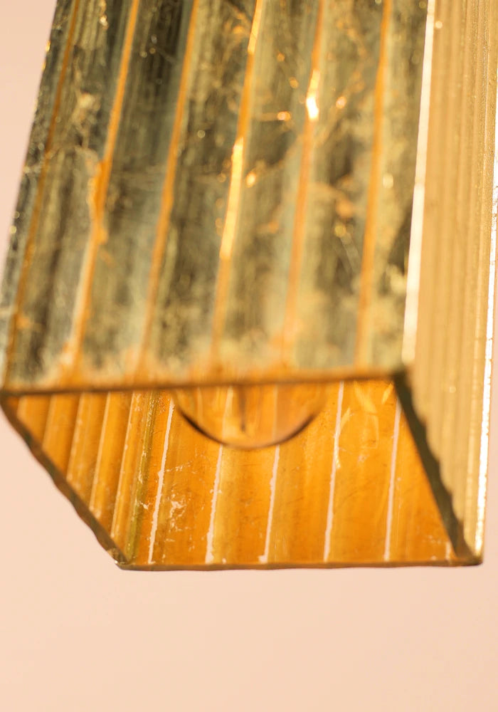 Close up of decorative gold pendant light on a beige background