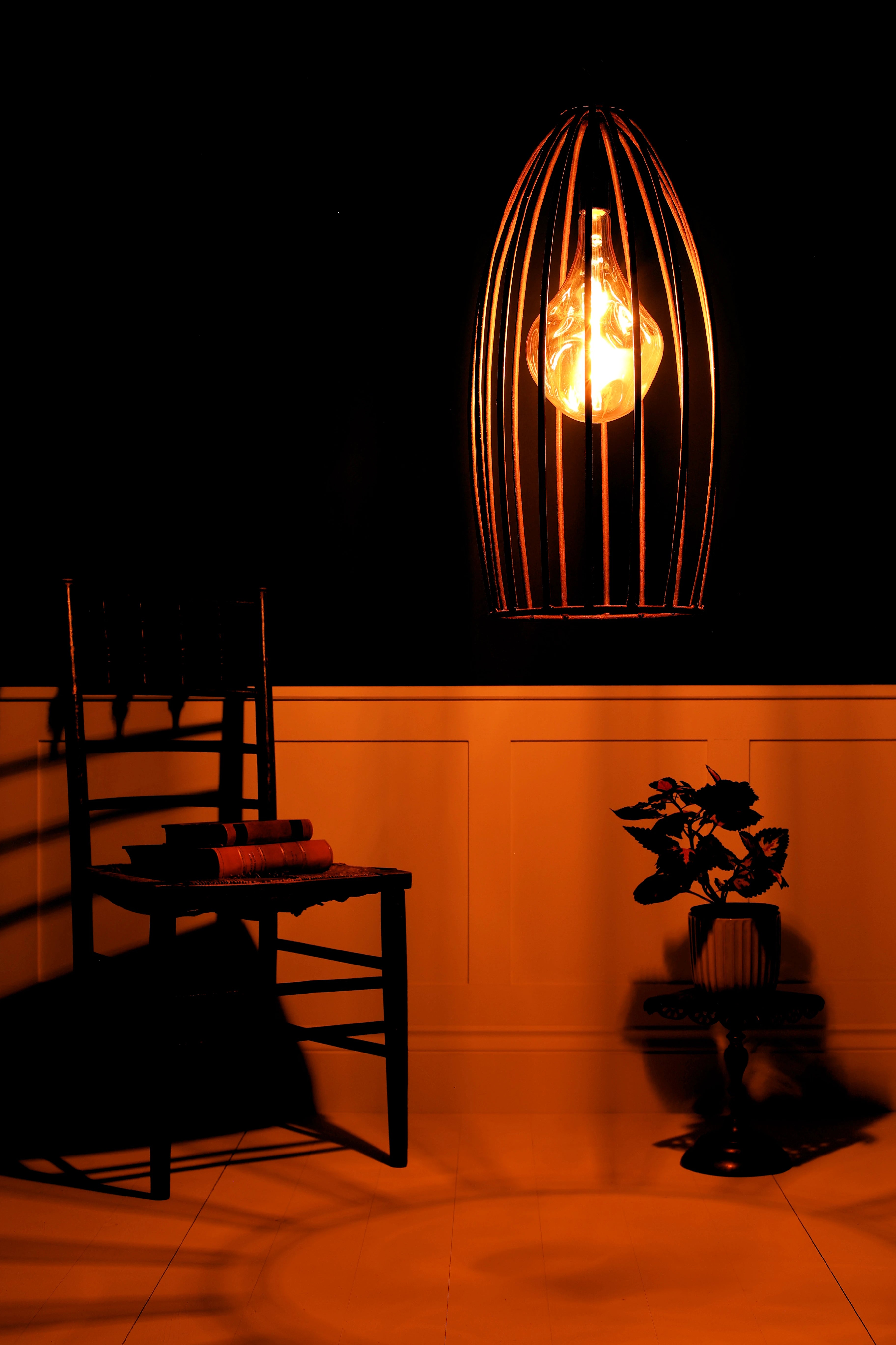 Ornate pendant light fixture casting a warm glow in a dimly lit room.