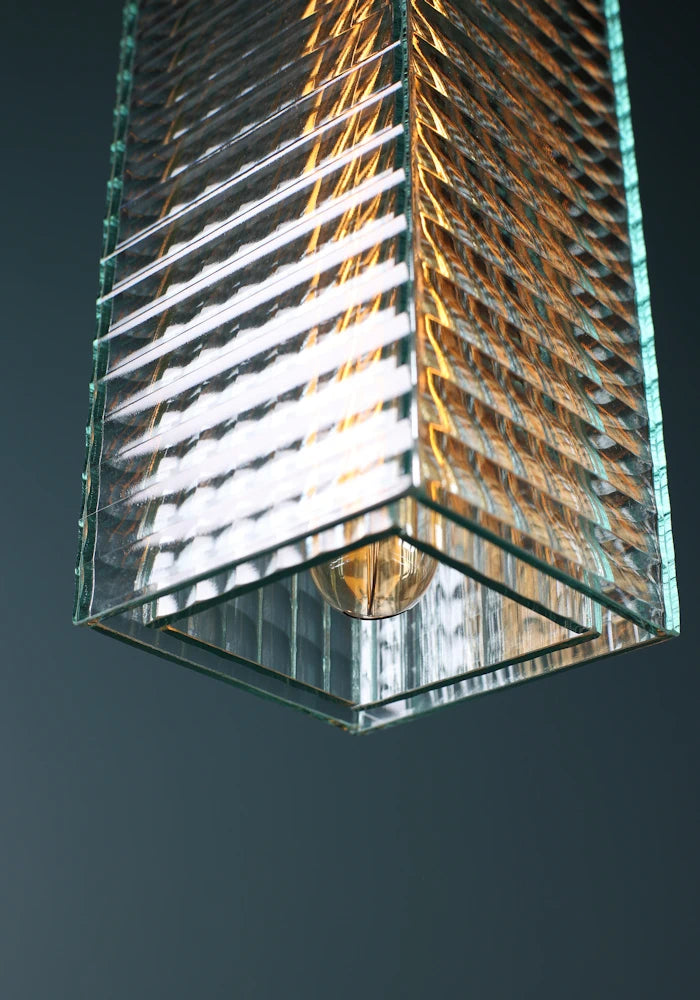 Close up of large ribbed glass bathroom pendant light switched off