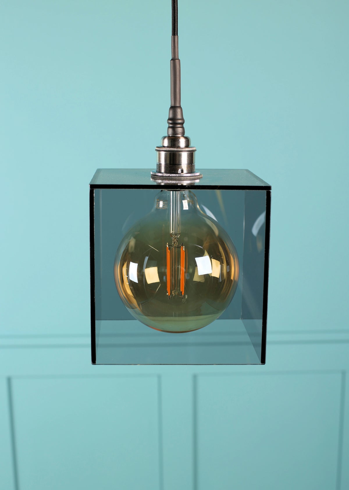 A smoked glass square pendant light, chrome lamp holder and Edison style light bulb