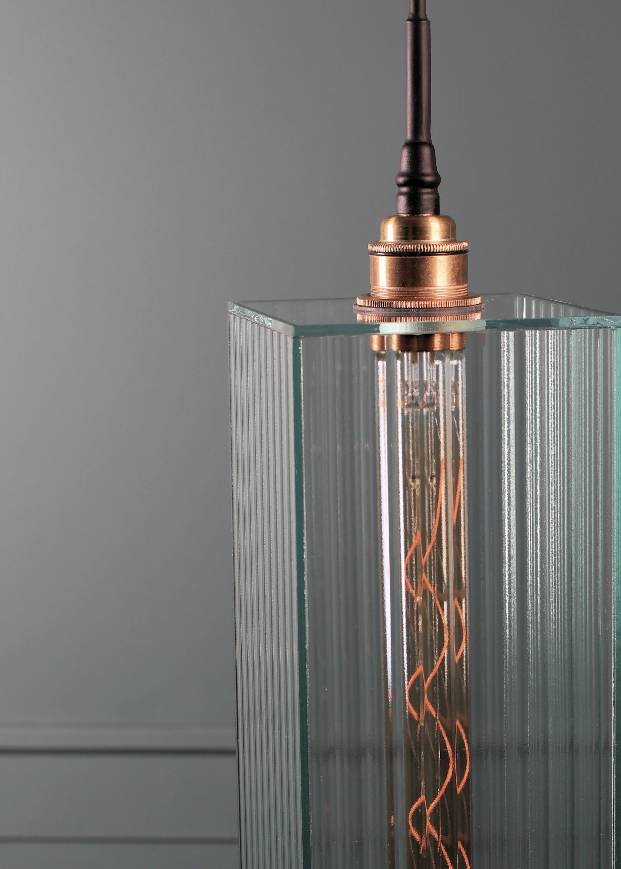 Large ribbed glass bathroom pendant light with brushed brass lamp holder.