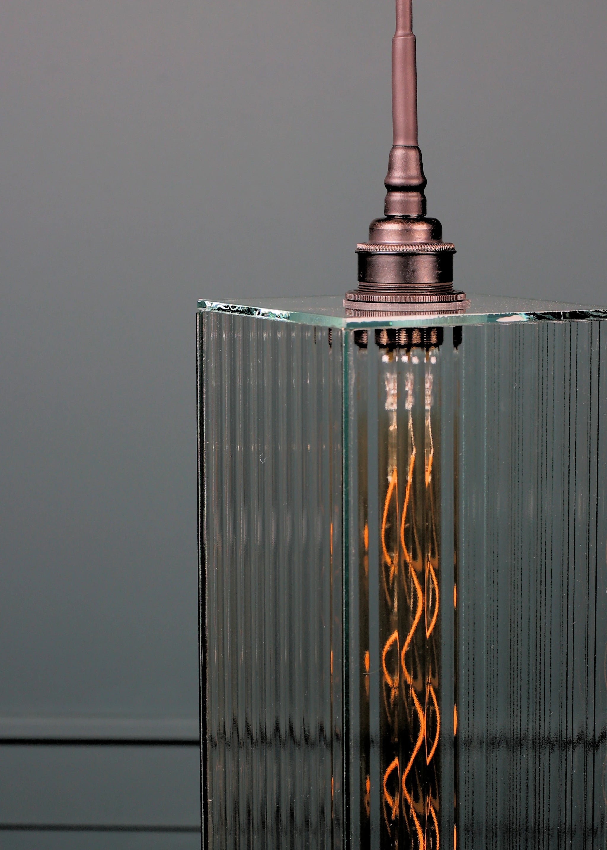 Large ribbed glass bathroom pendant light with antique bronze lamp holder.