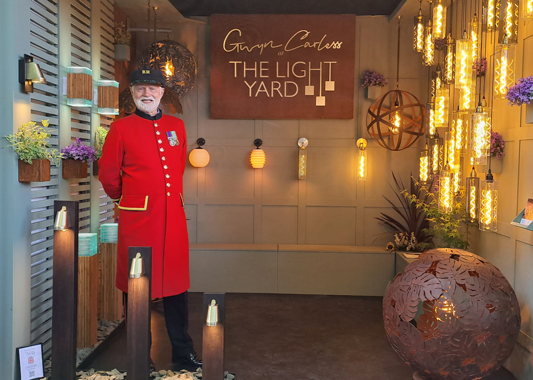 Man in a red uniform standing in a decorative interior setting with 'The Light Yard' sign.