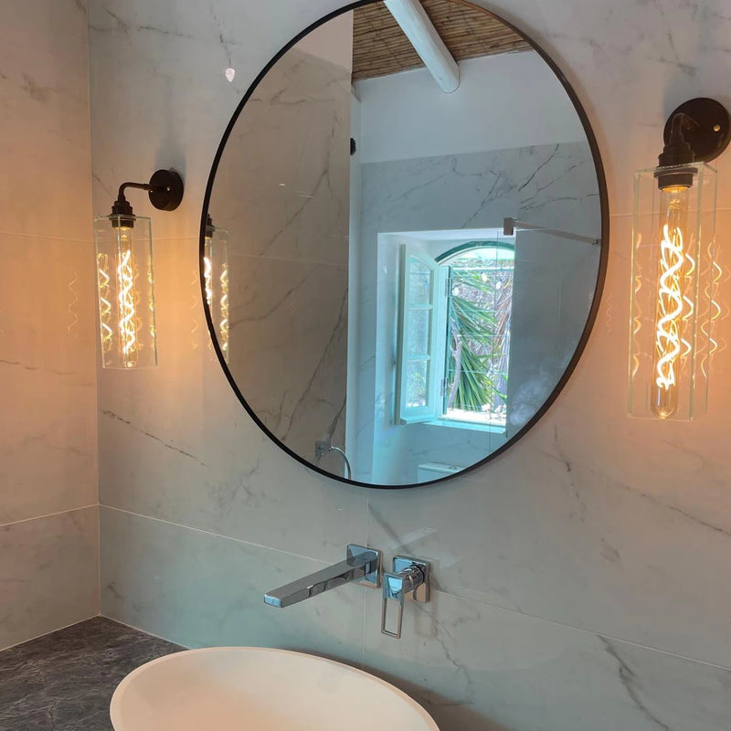 Round mirror on a marble wall with a window view, decorative glass bathroom wall lights
