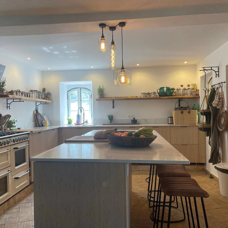 Modern kitchen with a central island, stools, with contemporary pendant light cluster 