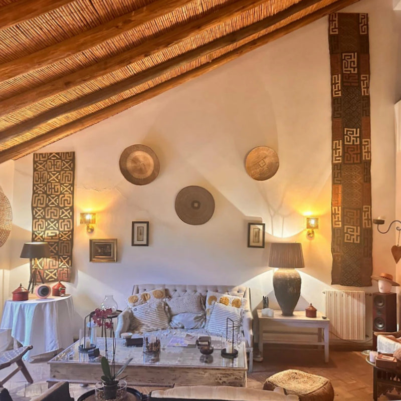 Living room with rustic decor, wooden ceiling, decorative wall elements and contemporary wall lights