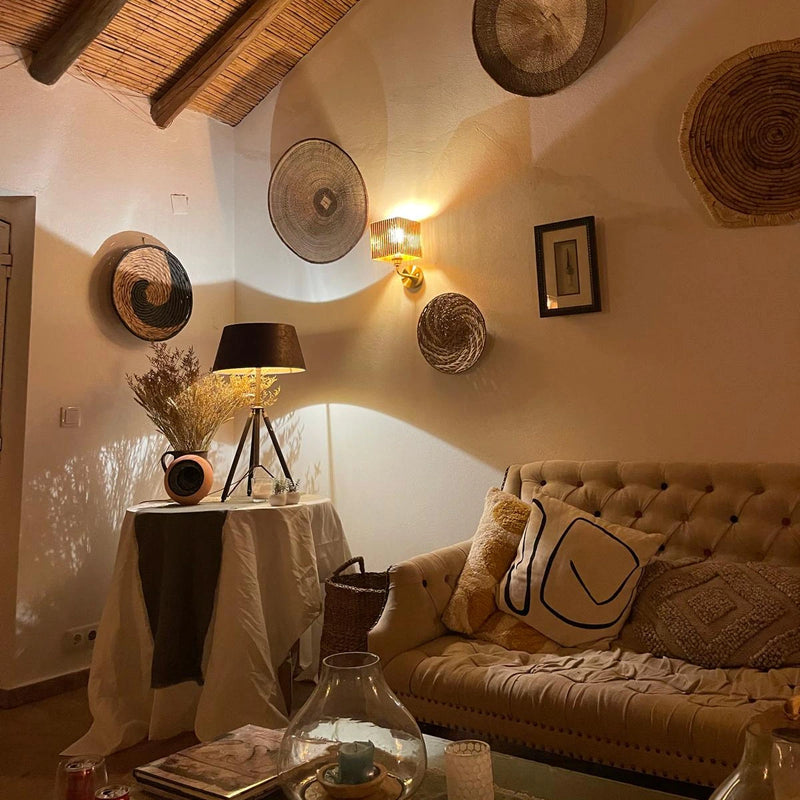 Cozy living room with a beige sofa, decorative pillows, wall art and contemporary wall light.