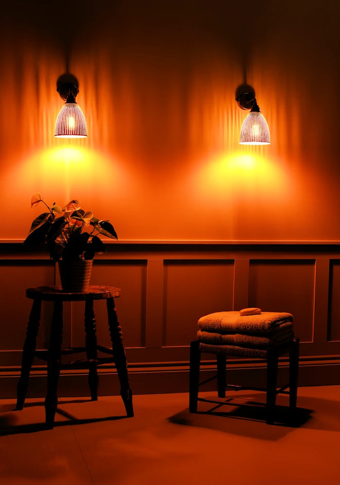 Elegant small bell fluted glass IP44 bathroom wall lights, stool with plant, bath towels