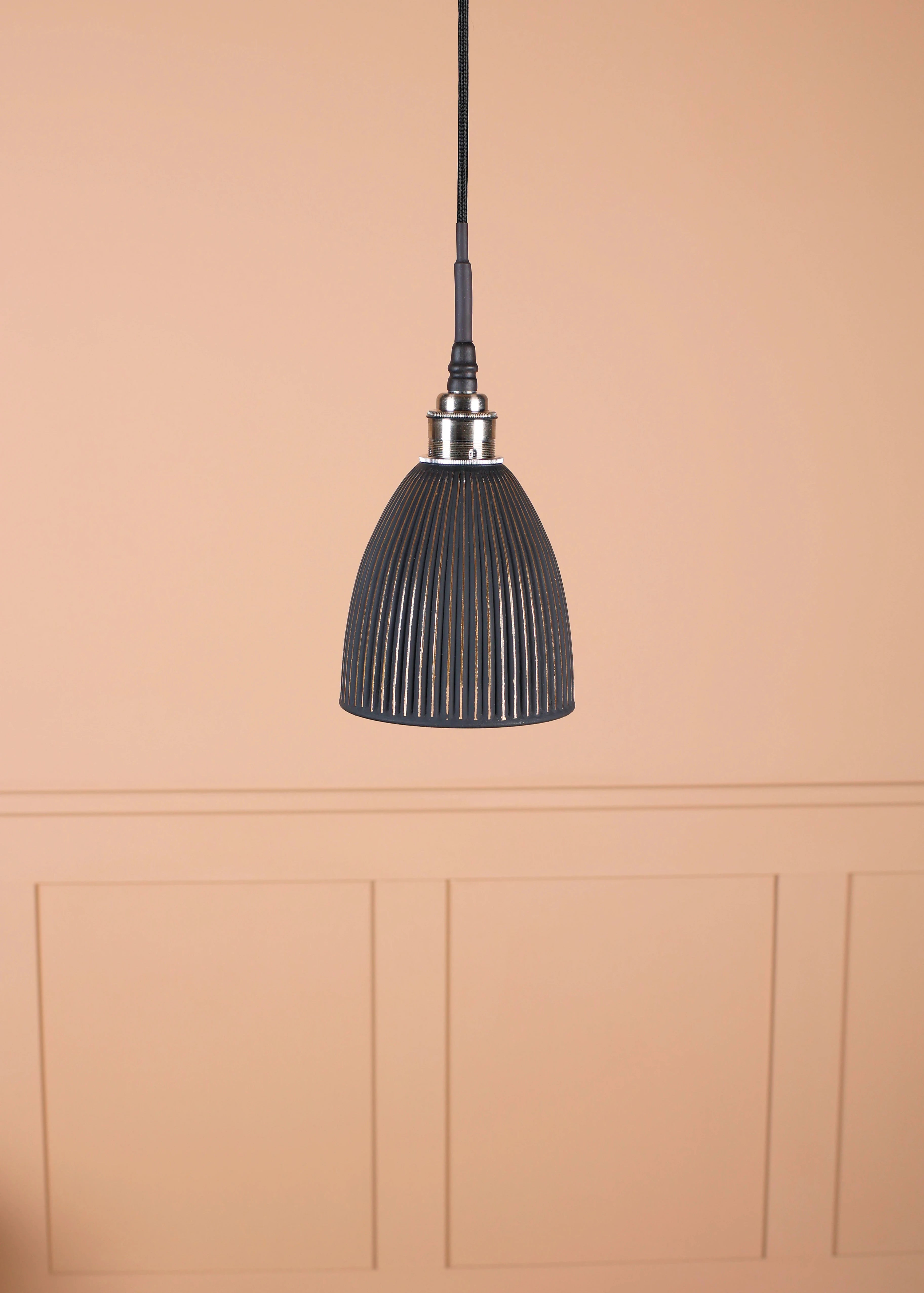 Black & gold bell shaped bathroom pendant light with nickel lamp holder on tan coloured panelled background