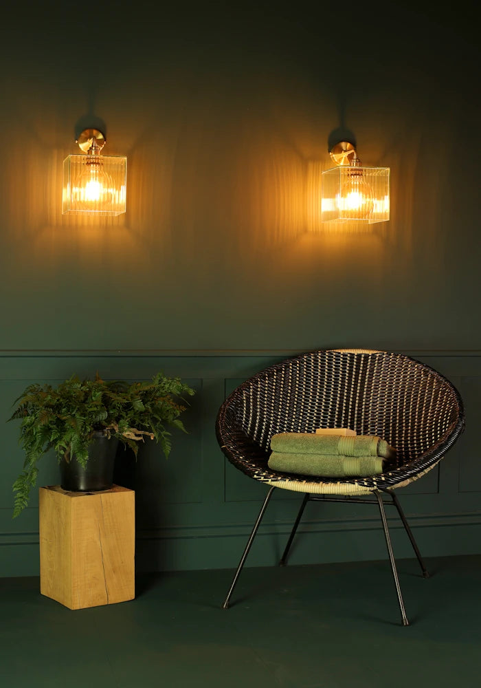 Elegant square ribbed glass IP44 bathroom wall lights, art deco chair with bath towels, pot plant