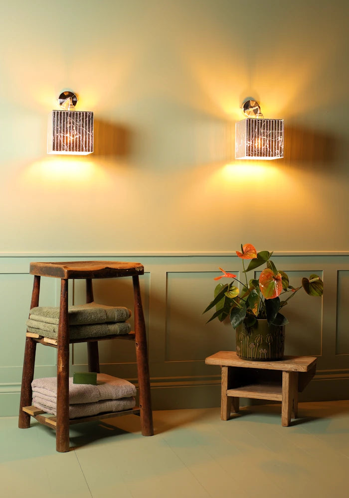 Elegant square silver leaf IP44 bathroom wall lights, wooden stool, bath towels pot plant