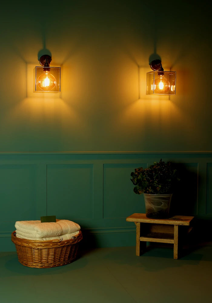 Elegant square smoked glass IP44 bathroom wall lights, basket with bath towels, pot plant