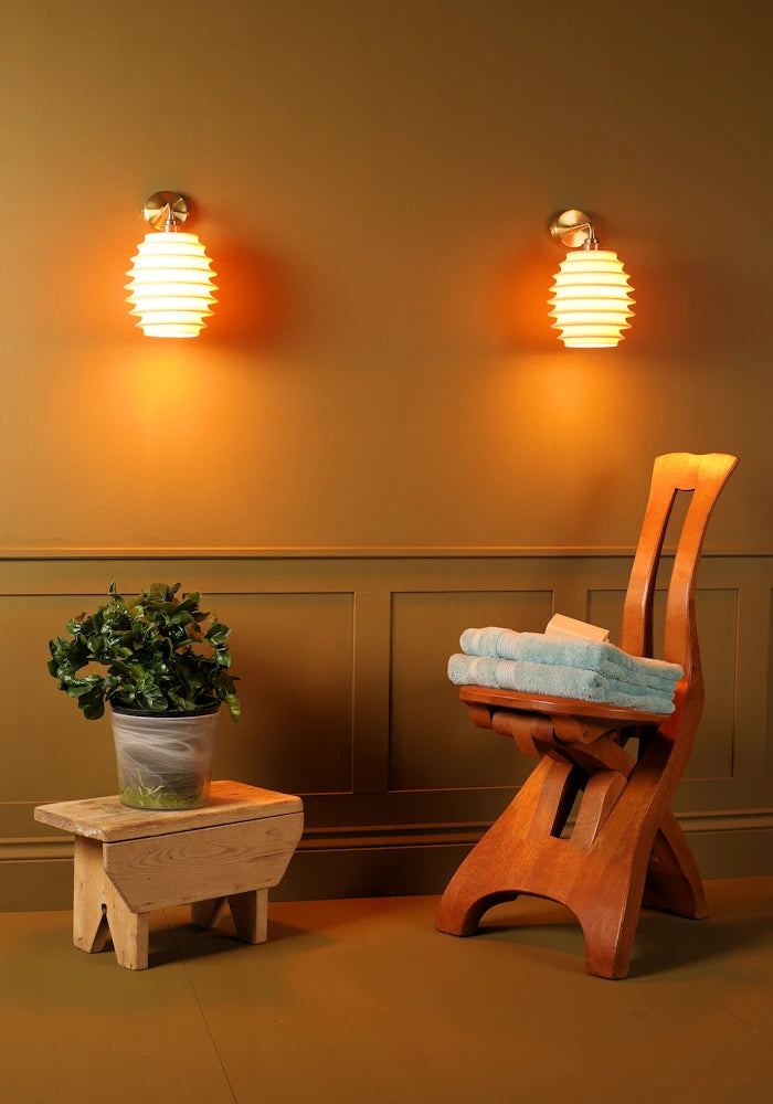 Elegant concertina style ceramic IP44 bathroom wall lights, pot plant, wooden chair with bath towels