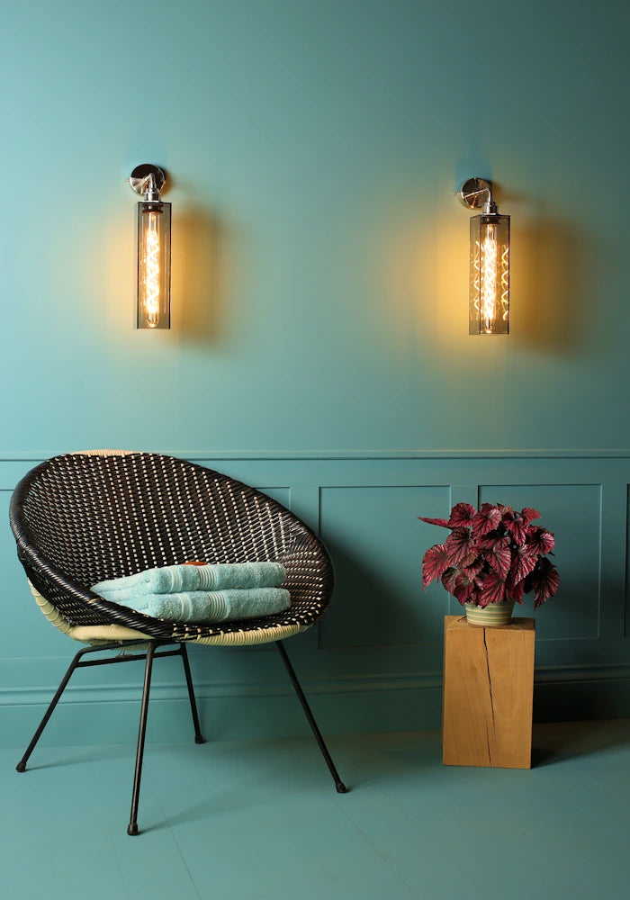 Elegant long smoked glass IP44 bathroom wall lights, art deco chair with bath towels, pot plant