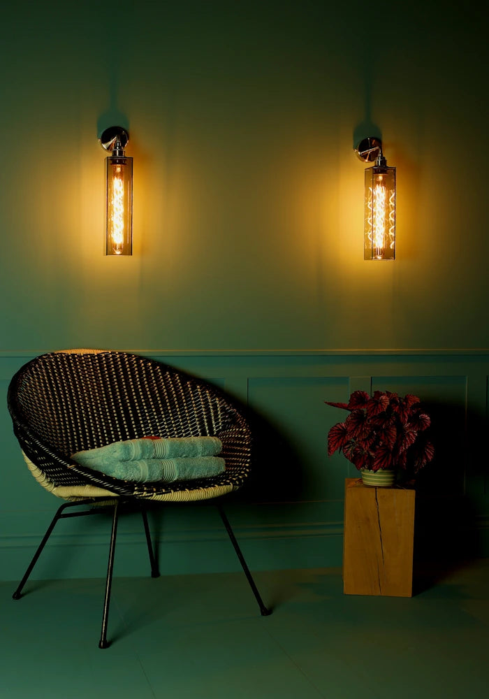 Elegant long smoked glass IP44 bathroom wall lights, art deco chair with bath towels, pot plant