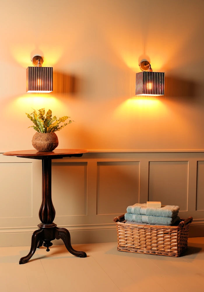 Elegant square black and gold IP44 bathroom wall lights, plant and basket with bath towels 