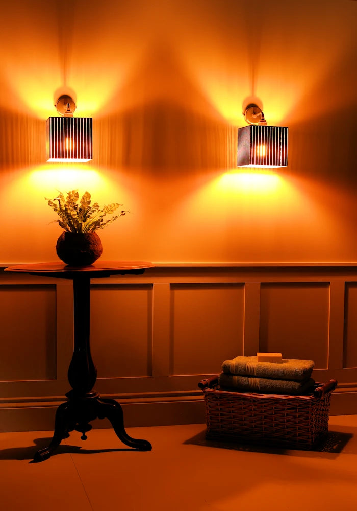 Elegant square black and gold IP44 bathroom wall lights, plant and basket with bath towels 
