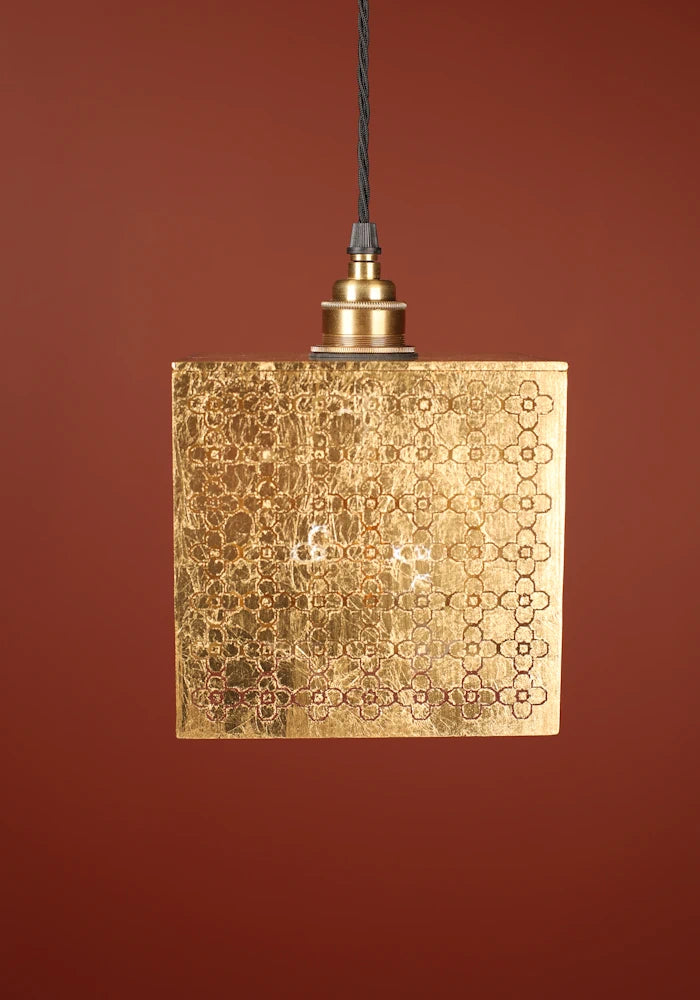 Cube gold leaf pendant light with Moroccan style pattern, brass lamp holder on red background