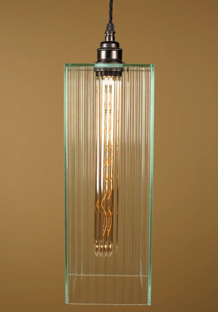 Pendant light with fluted glass shade, bronze lamp holder on a brown background