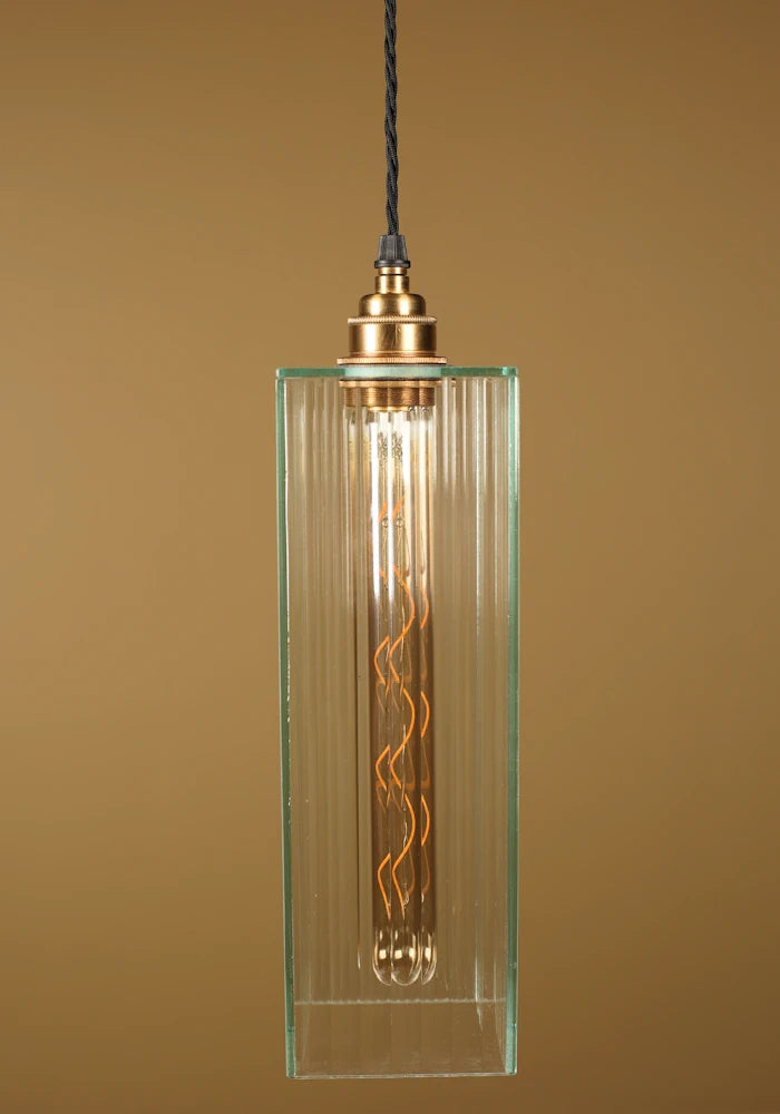 Vintage-style pendant light with a glass shade, brass lamp holder on a beige background