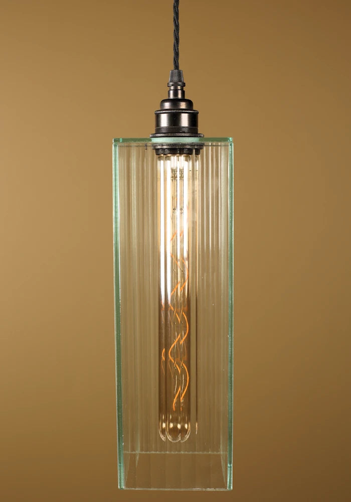 Vintage-style pendant light with a glass shade, bronze lamp holder on a beige background