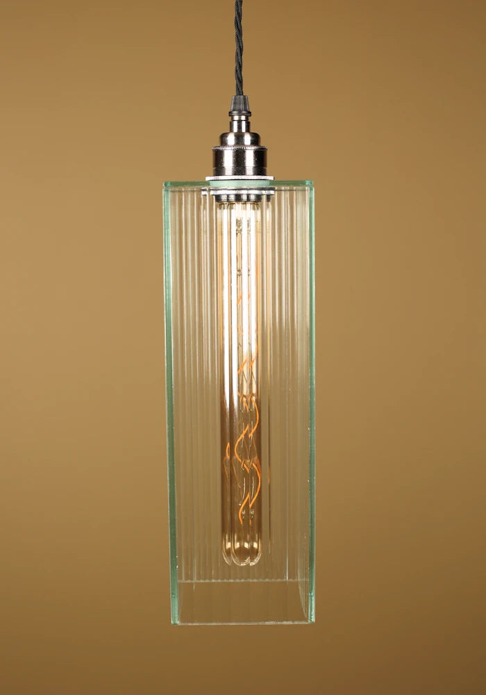 Vintage-style pendant light with a glass shade, nickel lamp holder on a beige background