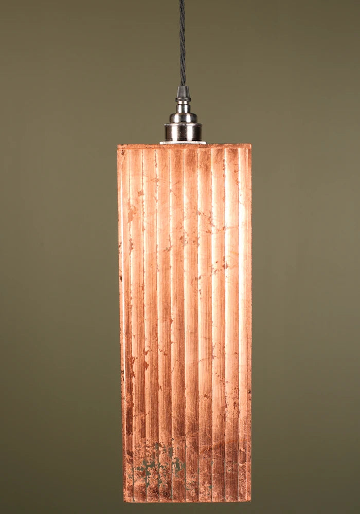 Copper pendant light with a ribbed design, nickel lamp holder on a green background