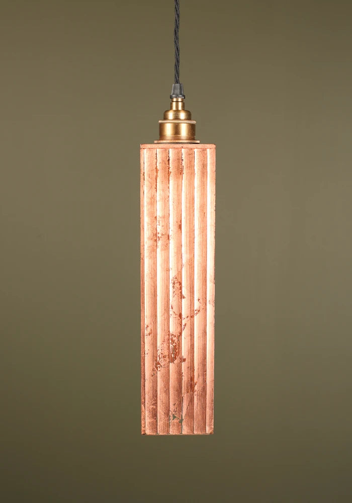 Copper pendant light with brass lamp holder on green background