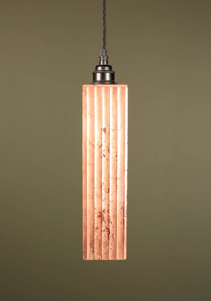 Copper pendant light with bronze lamp holder on green background