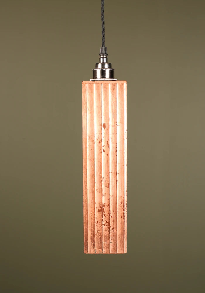 Copper pendant light with nickel lamp holder on green background