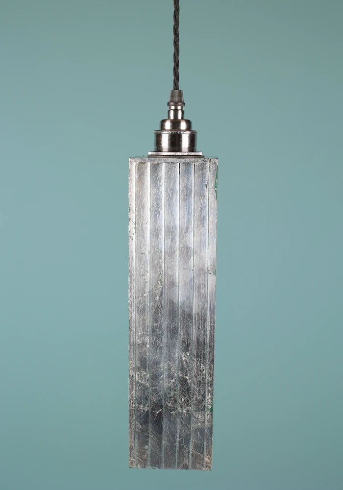 Slim, elegant silver pendant light with nickel lamp holder on blue background