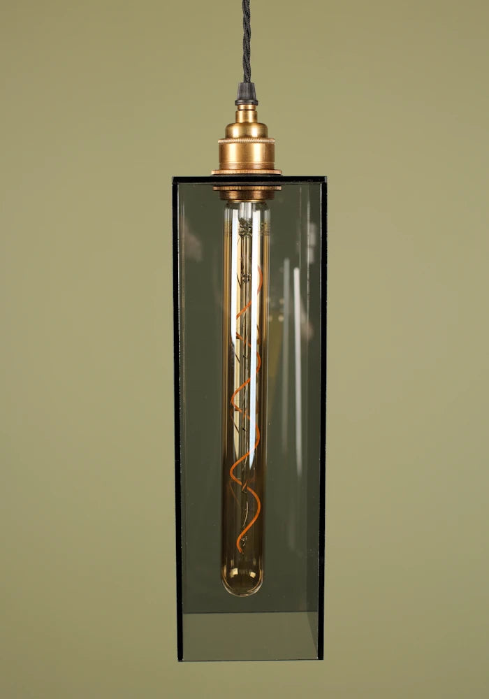 Mid size smoked glass pendant light with brass lamp holder on sage green background