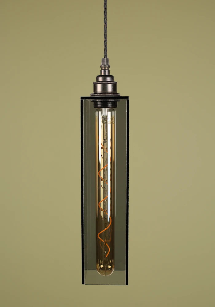 Pendant light with smoked glass shade, exposed bulb and bronze lamp holder against a beige background