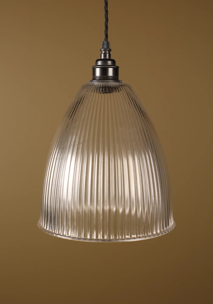 Bell shaped prismatic glass pendant light with bronze lamp holder on beige background