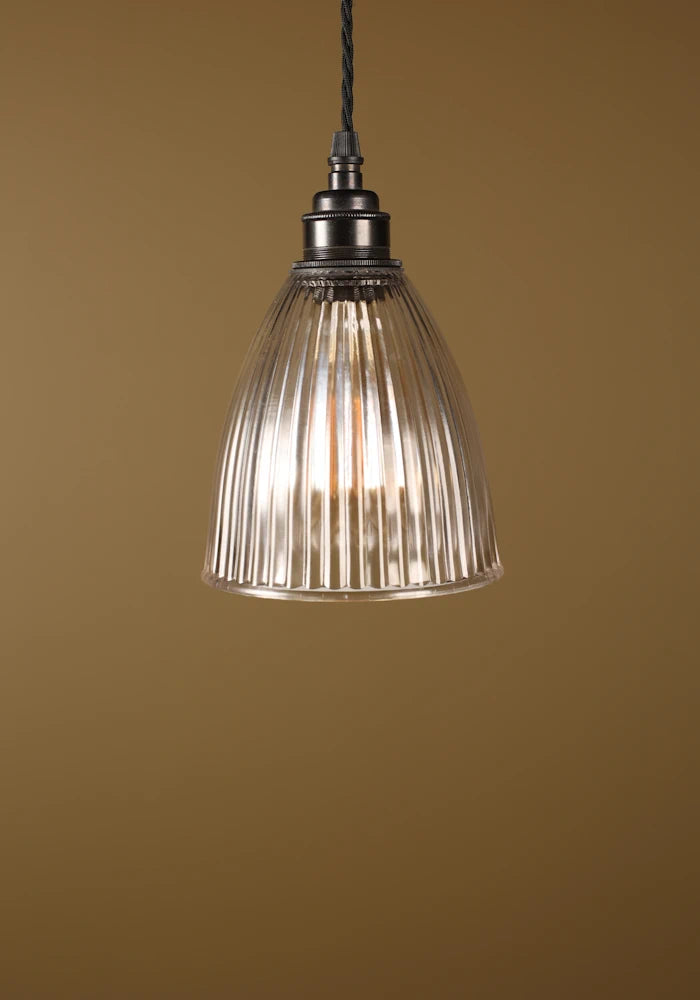 Small prismatic glass pendant light, bronze lamp holder on beige background
