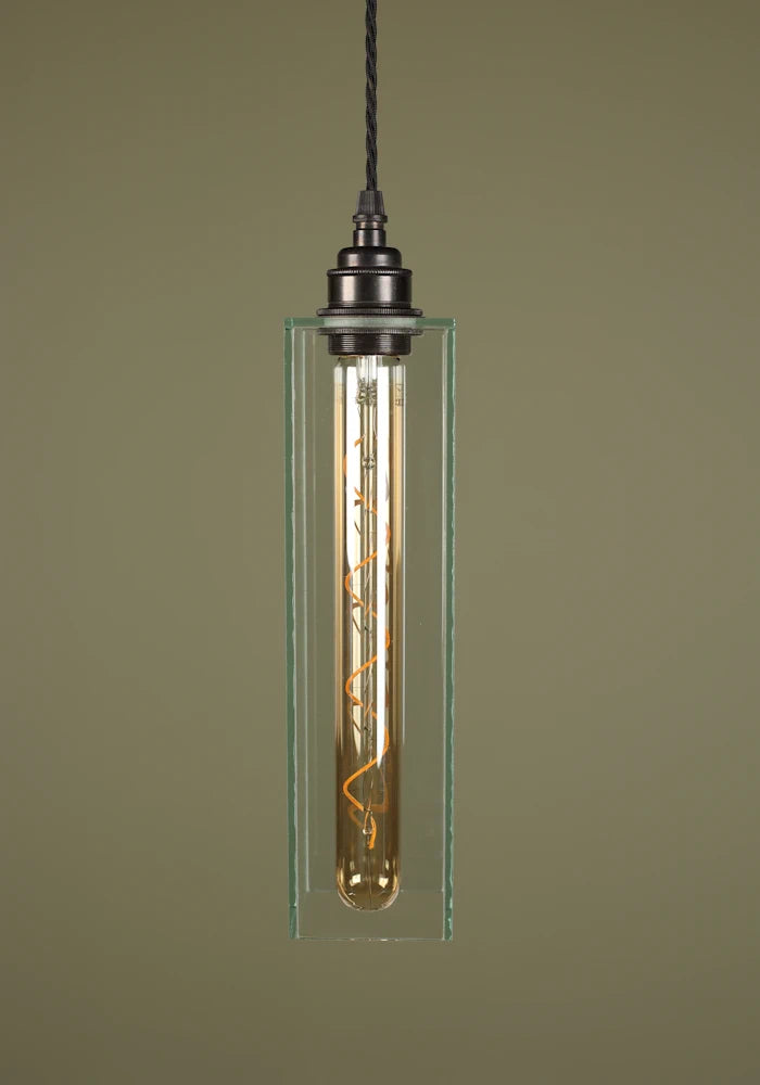 Elegant long clear glass pendant light with bronze lamp holder, sage green background