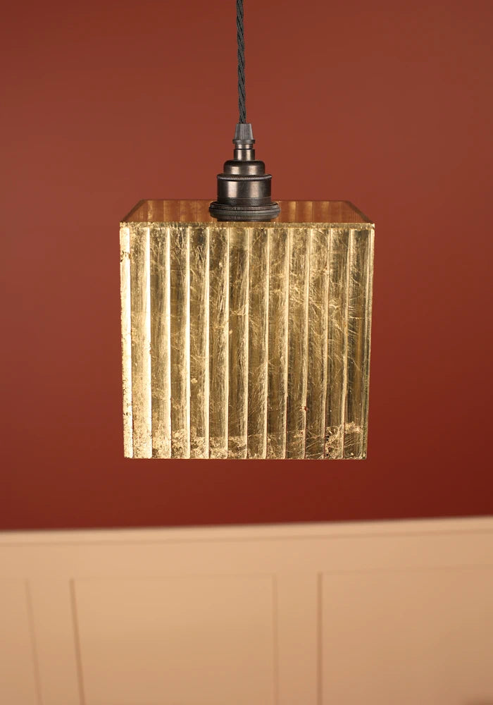 Close up of Gold leaf pendant cubed light with bronze lamp holder, red and cream background