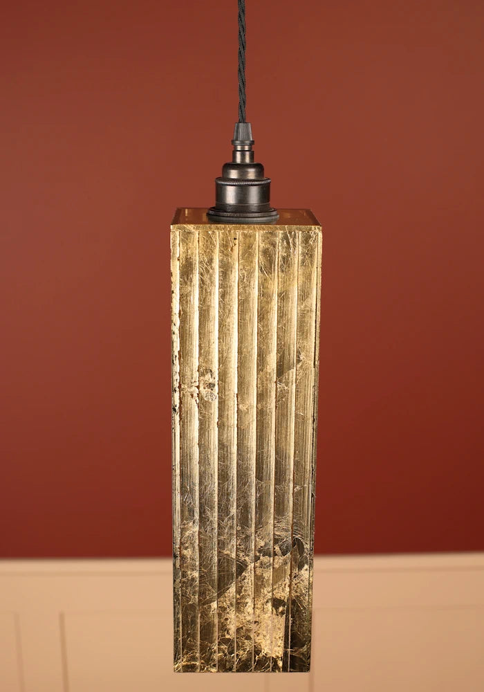 Pendant light with textured gold fixture, bronze lamp holder against a red-brown background