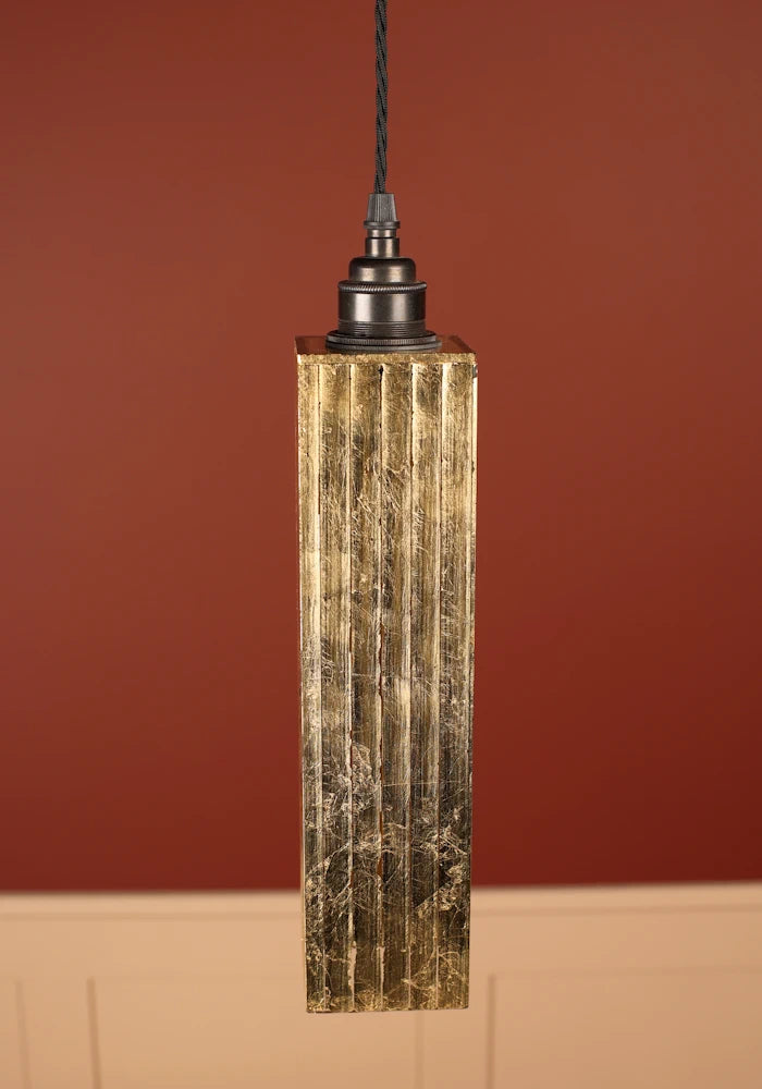 Elegant rectangular pendant light with gold leaf square shade, bronze lamp holder,  against a red wall 