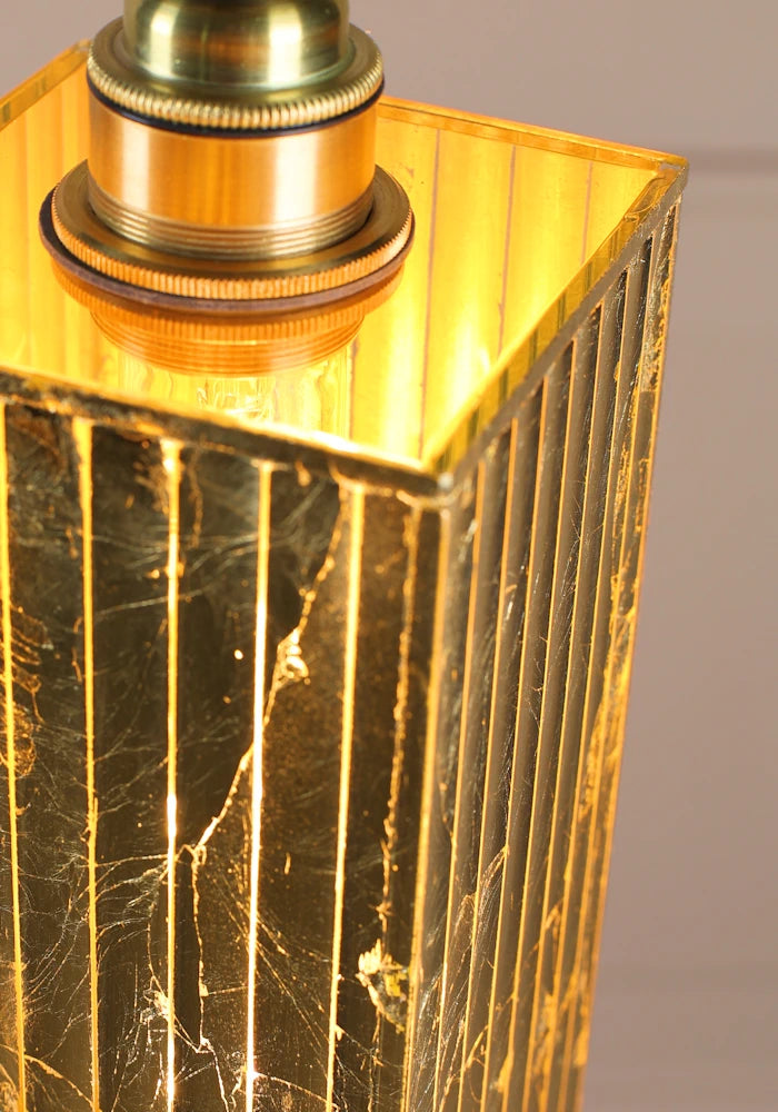 Gold textured lamp with a metallic base on a gray background