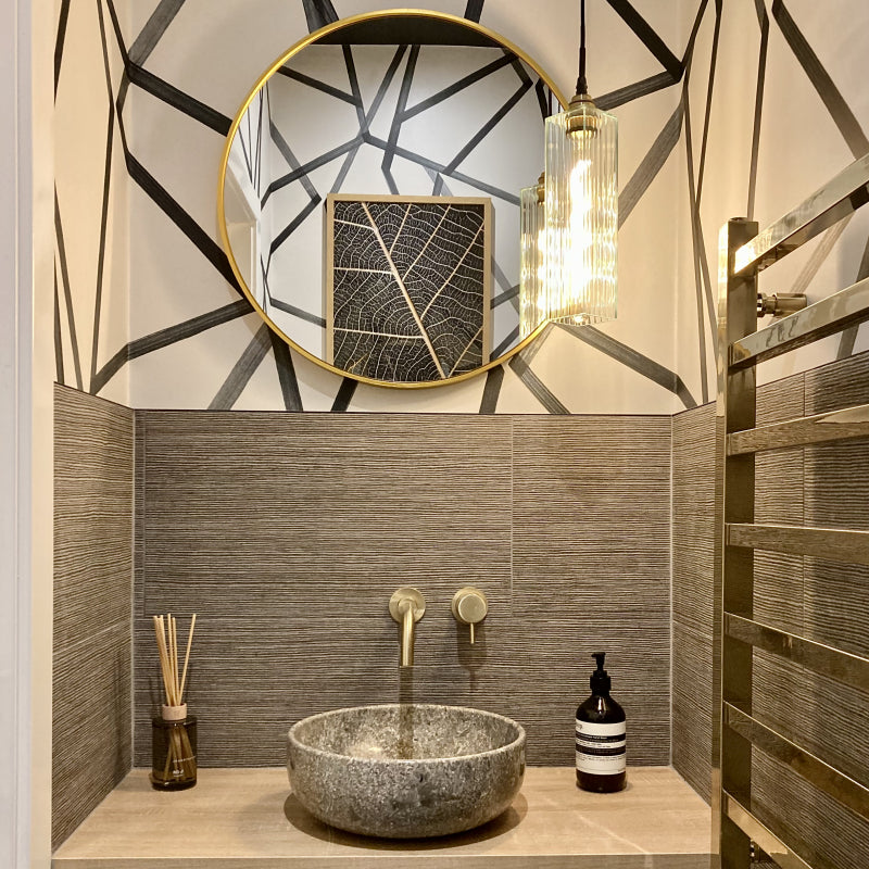Decorative glass pendant light hanging with round mirror and stone sink in modern bathroom  